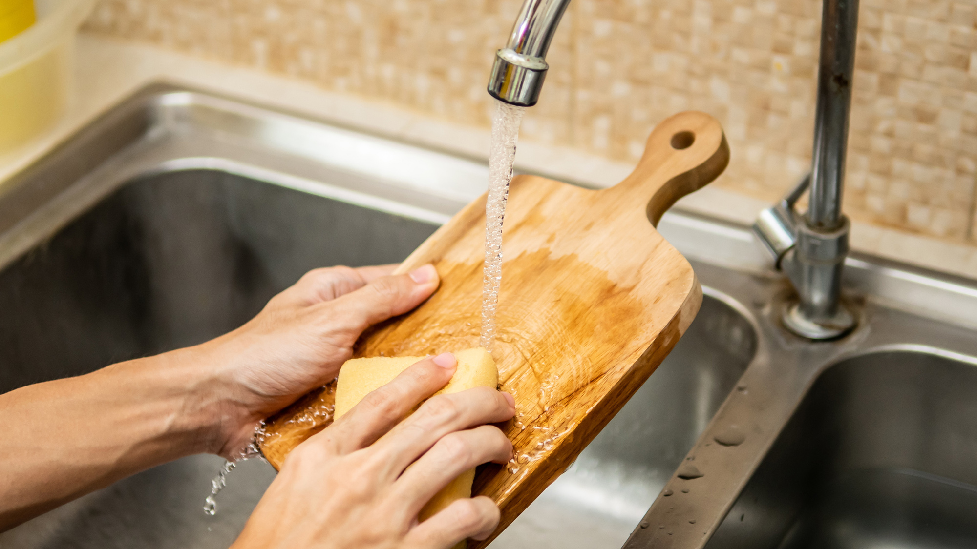 Cleaning wood cutting board in kitchen sink